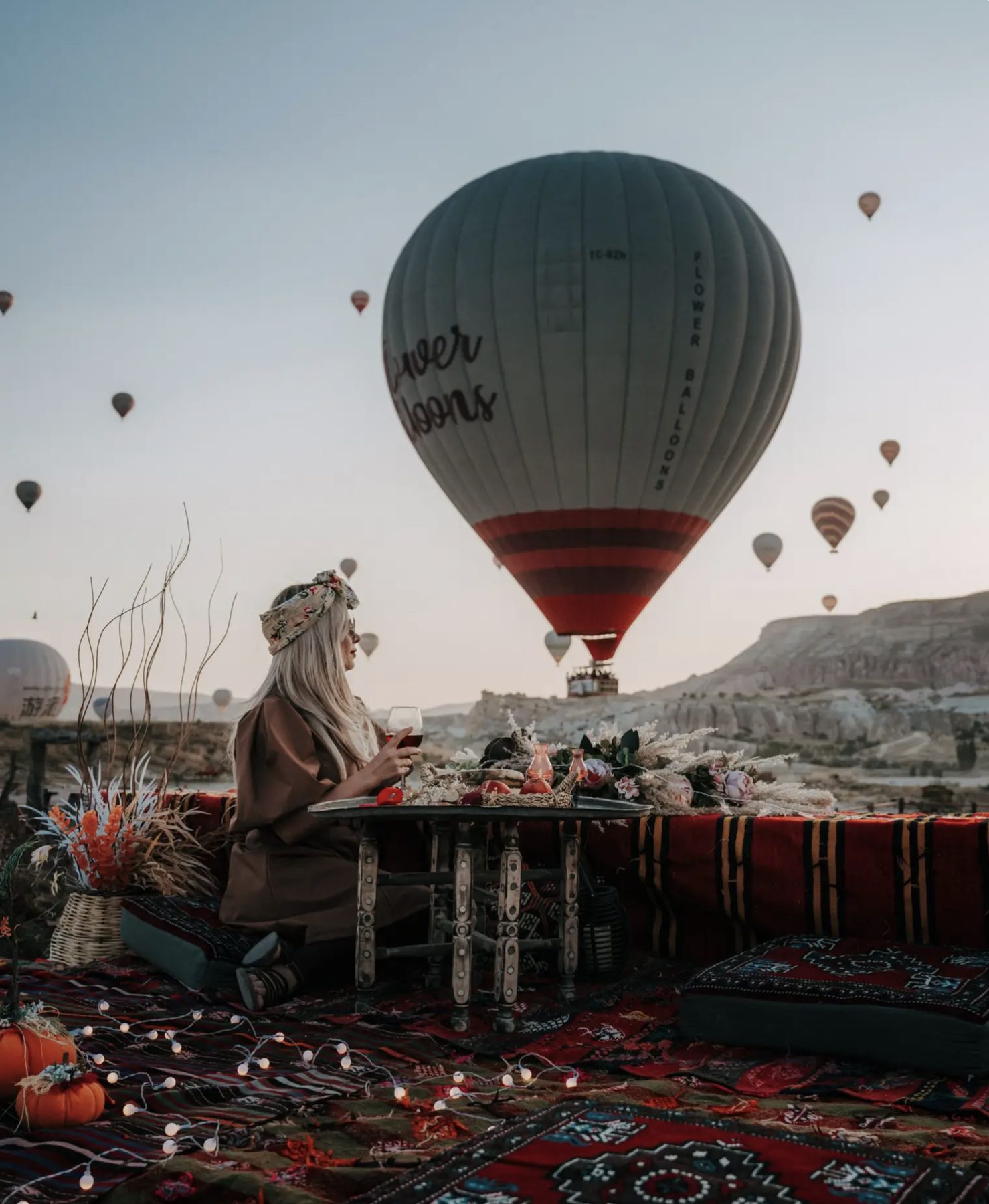 Carpet picnic styling with hot air balloons rising behind in Cappadocia